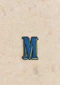 Ecusson vert / bleu - Lettre M - Bleu